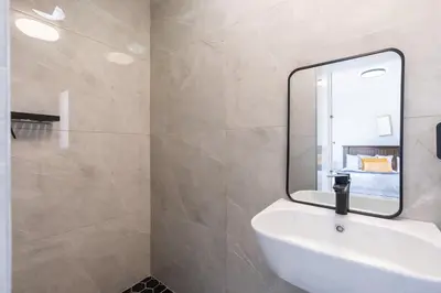 a bathroom with a white sink and a mirror at Surfside Haven, 3 Bed Townhouse in Cape Town