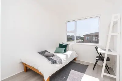 a white room with a bed and a ladder and a window at Surfside Haven, 3 Bed Townhouse in Cape Town