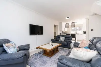 a living room with couches and a coffee table at Surfside Haven, 3 Bed Townhouse in Cape Town
