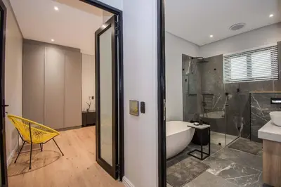 a bathroom with a tub and a sink and a bath tub at Modern House Dalsig Stellenbosch in Stellenbosch