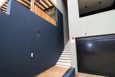 a garage with a blue door and a staircase at Modern House Dalsig Stellenbosch in Stellenbosch
