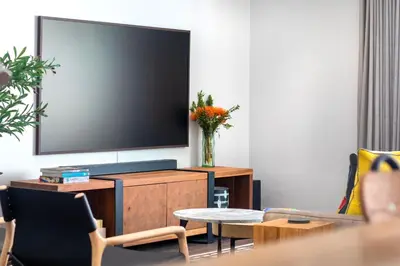 a living room with a flat screen tv on a cabinet at House La Gratitude - secure parking in Stellenbosch