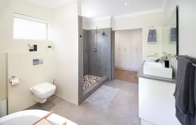 a bathroom with a shower and a toilet and a sink at House La Gratitude - secure parking in Stellenbosch