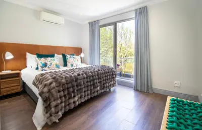 a bedroom with a bed and a large window at House La Gratitude - secure parking in Stellenbosch