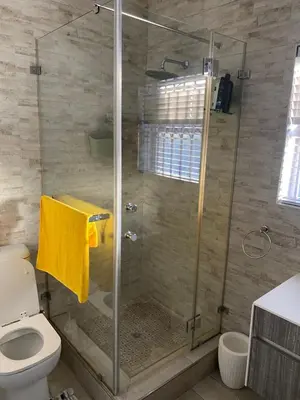 a shower with a glass door in a bathroom at KBJ House in Cape Town