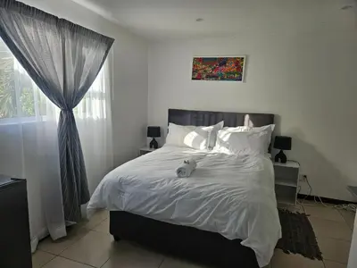 a bedroom with a bed with a teddy bear on it at Cozy Private Studio in Cape Town
