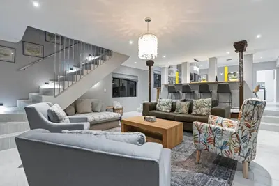 a living room with couches and a staircase at Flamingo Bay Manor in Fisherhaven