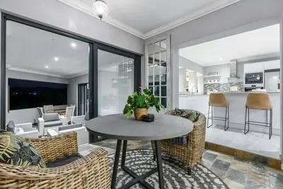 a kitchen and living room with a table and chairs at Flamingo Bay Manor in Fisherhaven