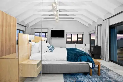 a bedroom with a king sized bed and a television at Flamingo Bay Manor in Fisherhaven