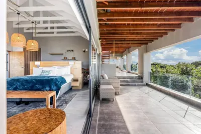 a bedroom with a bed and a balcony at Flamingo Bay Manor in Fisherhaven