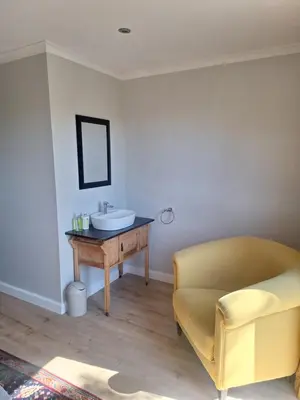 a bathroom with a sink and a chair at Governor's nest in Cape Town
