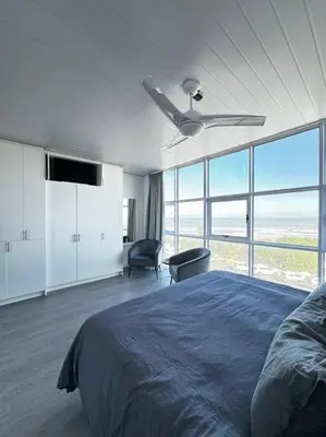 a bedroom with a bed and a ceiling fan at Soete Rus Strand in Cape Town