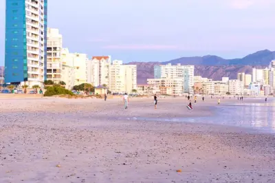a group of people on a beach with buildings at Soete Rus Strand in Cape Town