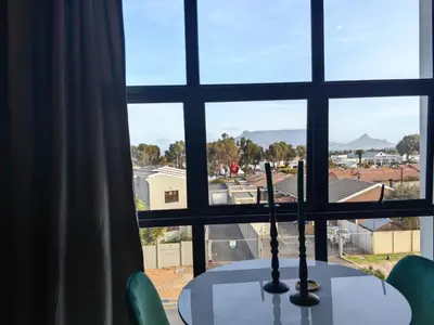 a table with a candle in front of a window at Ultra-Modern Studio Apartment in Table View