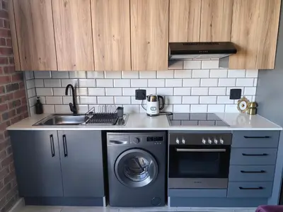 a kitchen with a sink and a washing machine at Ultra-Modern Studio Apartment in Table View