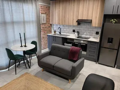 a kitchen with a couch and a table in a kitchen at Ultra-Modern Studio Apartment in Table View