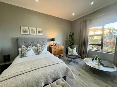 a bedroom with a bed and a table and a window at Room With A View in Windsor Park
