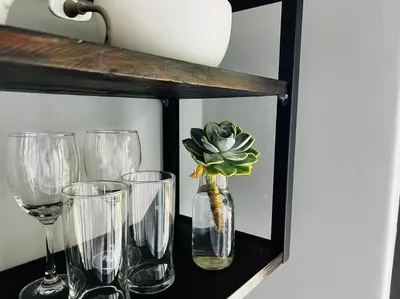 a shelf with wine glasses and a plant in a vase at Room With A View in Windsor Park