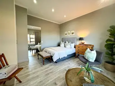 a bedroom with a bed and a table and chairs at Room With A View in Windsor Park