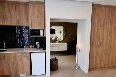 a kitchen with wooden cabinets and a white refrigerator at C'est la Vie 1 in Franschhoek
