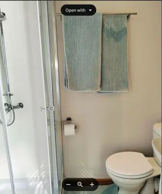 a small bathroom with a toilet and a shower at C es Cape in Pringle Bay
