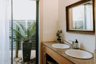 a bathroom with two sinks and a mirror at little villa in the vineyard in Stellenbosch
