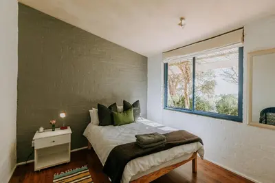 a bedroom with a large bed and a window at little villa in the vineyard in Stellenbosch