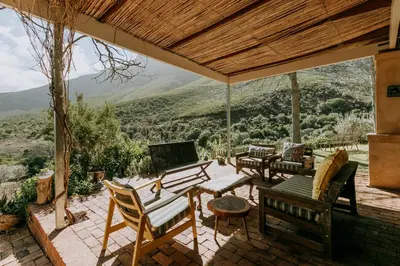 a patio with chairs and a table with a view at little villa in the vineyard in Stellenbosch