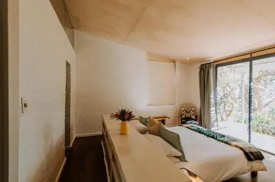 a bedroom with a large bed and a window at little villa in the vineyard in Stellenbosch