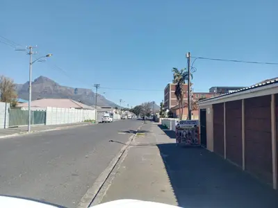 an empty street in a town with a mountain in the background at One Bedroom Apartment in Cape Town