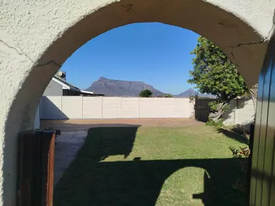an archway leading into a yard with a fence at Mountain View Apartment in Cape Town