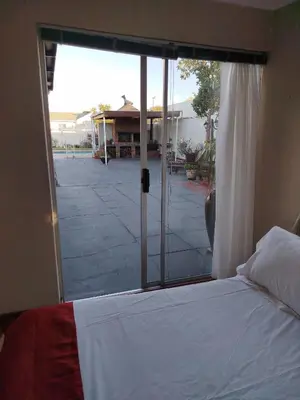 a bedroom with a bed and a sliding glass door at Mountain View Apartment in Cape Town