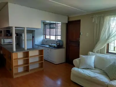a living room with a couch and a kitchen at Mountain View Apartment in Cape Town