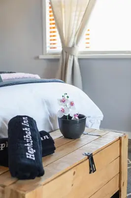 a wooden table with a bowl of flowers on a bed at Hephzibah Inn River Cabin in Hermon