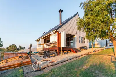 a house with a porch and a yard at Hephzibah Inn River Cabin in Hermon