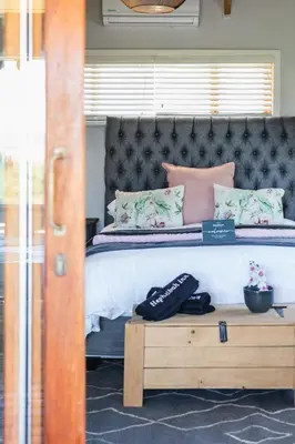 a bedroom with a large bed with a wooden table at Hephzibah Inn River Cabin in Hermon
