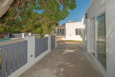 a driveway leading to a house with a fence at Hermanus Garden Studios in Hermanus