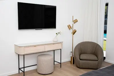 a bedroom with a desk and a chair and a television at Coco Queen in Paarl