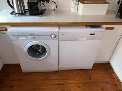 a washer and dryer under a counter in a kitchen at Bay View Cabin in Gordonʼs Bay