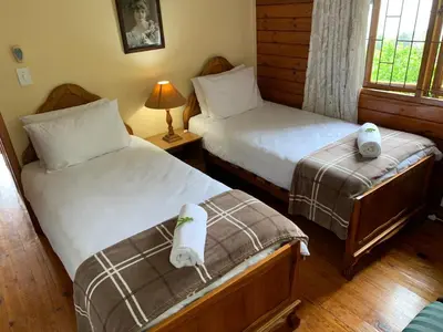 a bedroom with two beds with towels on them at Bay View Cabin in Gordonʼs Bay
