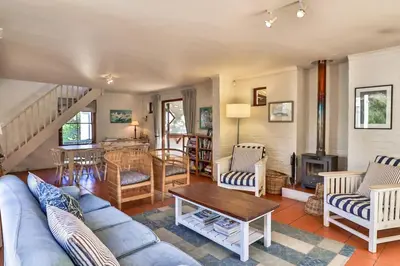a living room with a couch and a table at Hilbre House in Bettyʼs Bay