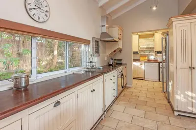 a large kitchen with a large clock on the wall at Whispering Waves in Hermanus