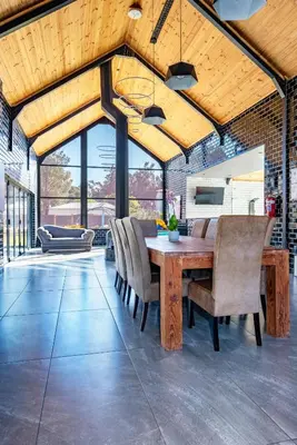 a dining room with a wooden table and chairs at The Glass Castle in Sir Lowry Pass