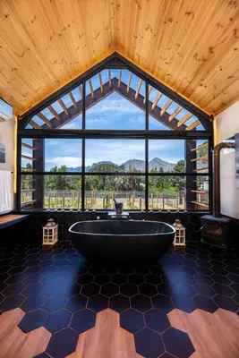 a large tub in a room with a large window at The Glass Castle in Sir Lowry Pass