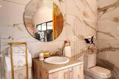 a bathroom with a sink and a mirror at Golden Sunset Room in Sir Lowry Pass