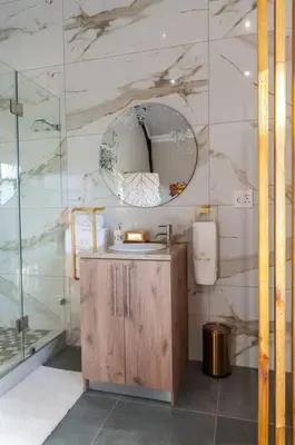 a bathroom with a sink and a mirror at Golden Sunset Room in Sir Lowry Pass