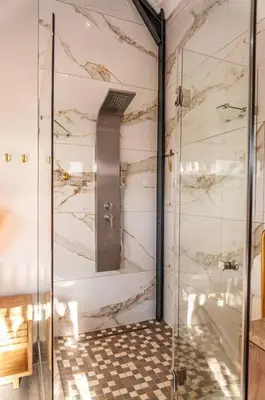 a bathroom with a shower with a glass door at Golden Sunset Room in Sir Lowry Pass