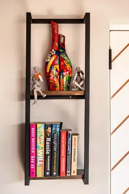 a black book shelf with books and a vase at Serenity Vista Retreat in Cape Town