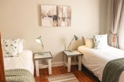 a bedroom with two beds and two tables with lamps at The View Guesthouse & Cottage in Caledon
