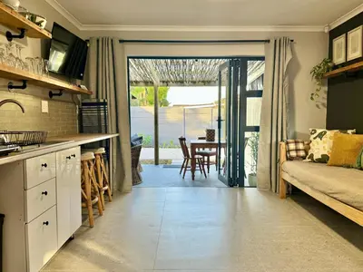 a kitchen and living room with a couch and a table at Stones - Cape Town Self Catering in Cape Town